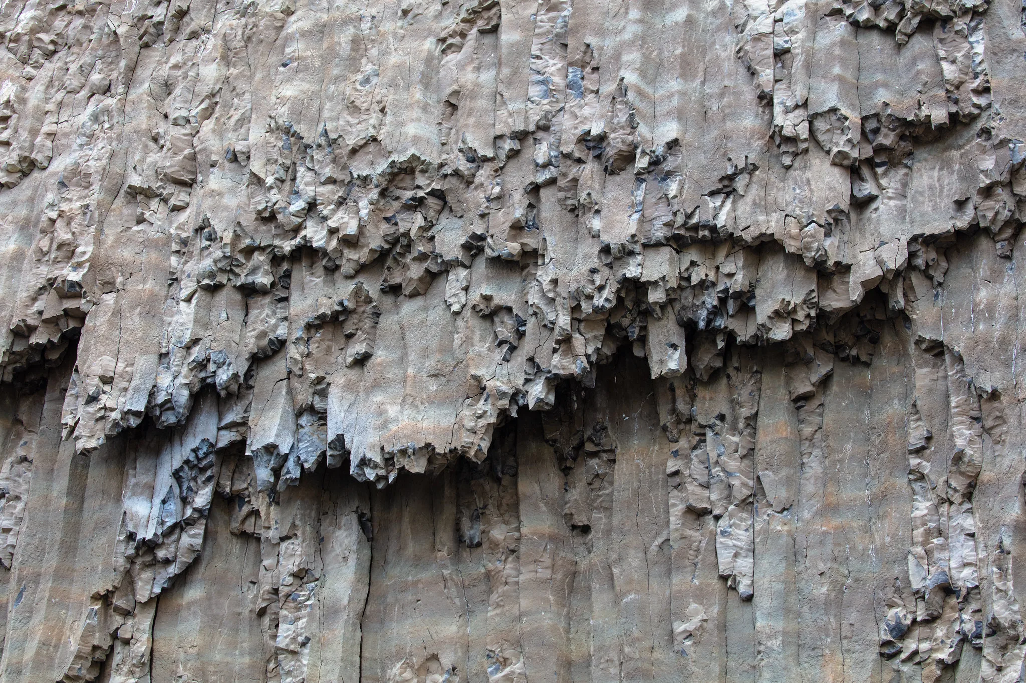 Tall natural basalt columns, with distinct layers and rough stone surfaces